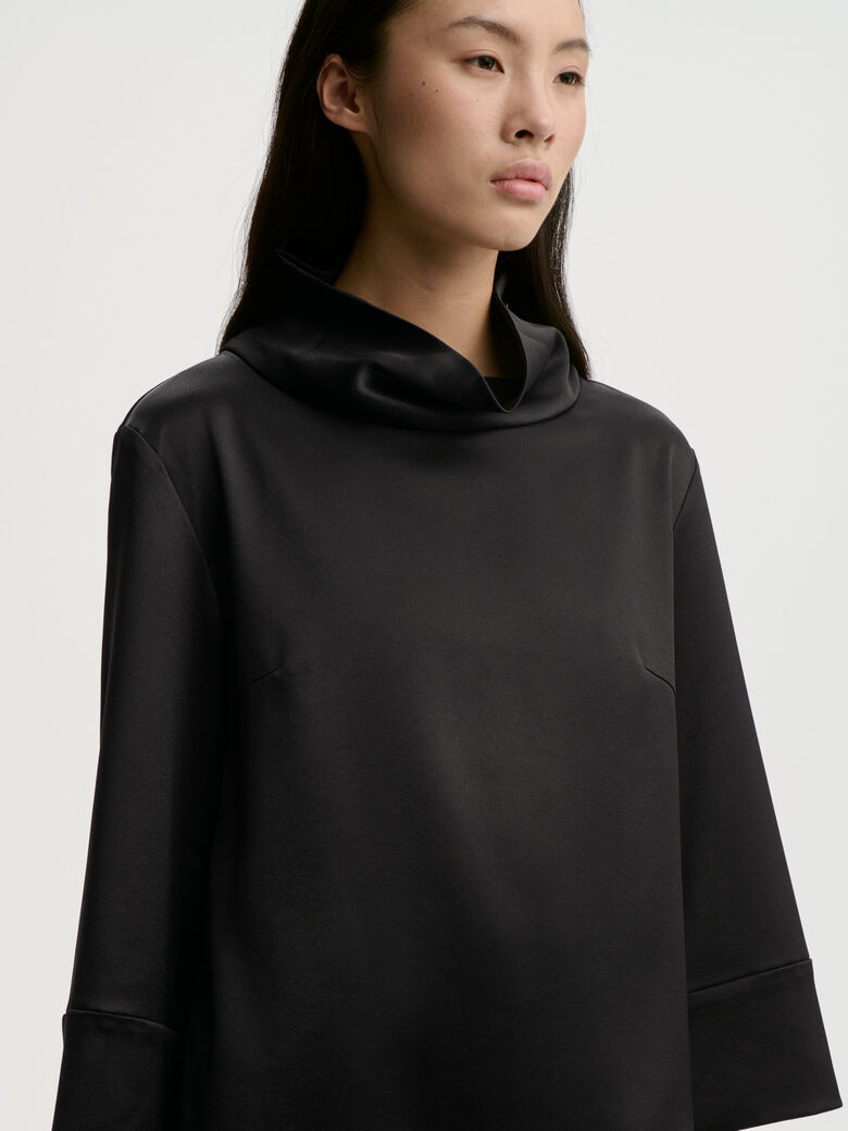 VICA bluse fra By Malene Birger i fargen sort, laget i 85% acetat og 15% polyester sateng. Vid, løs hals og cropped ermelengde.