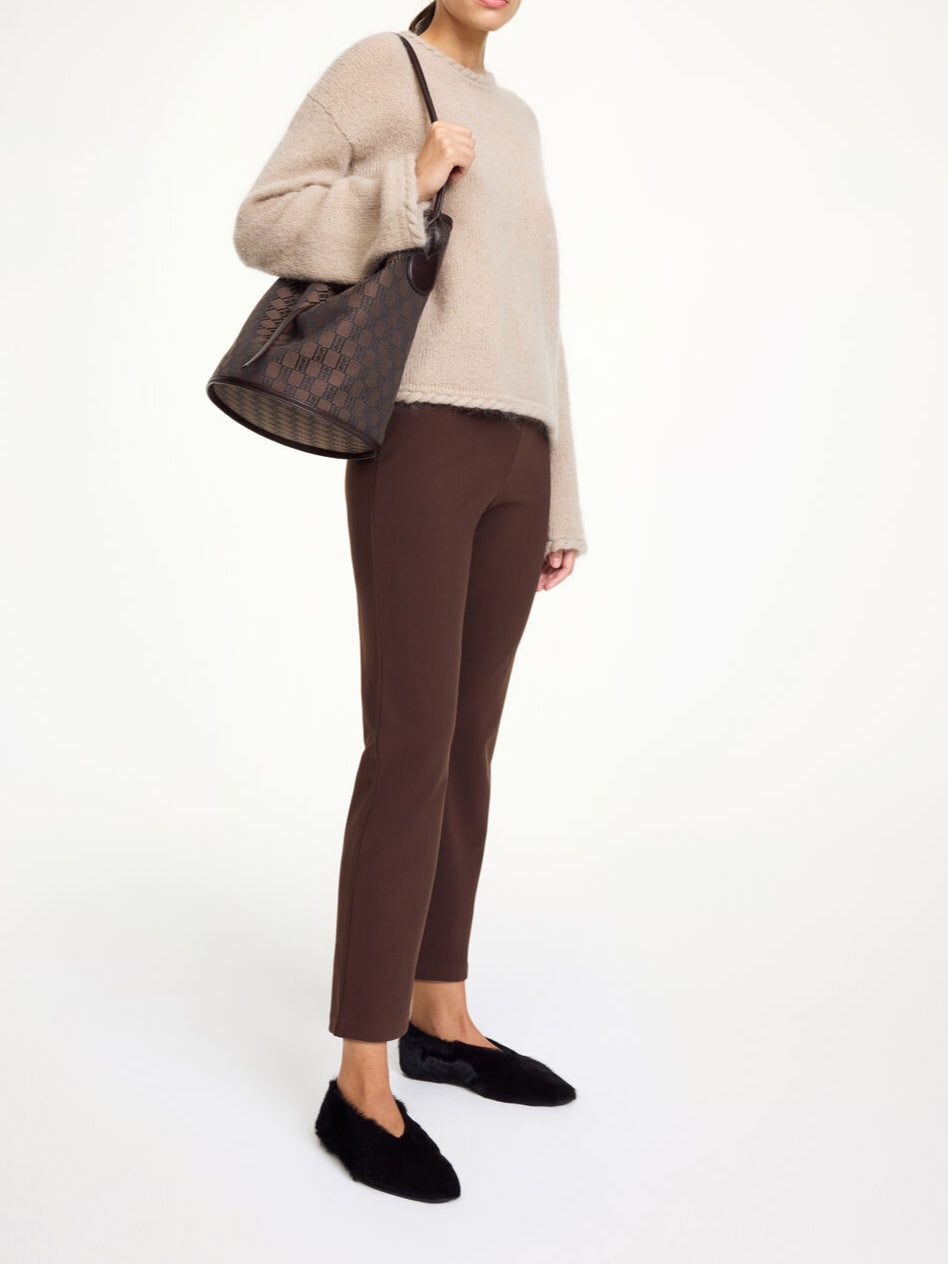 By Malene Birger Vilea bukse i brun, med strikk i livet og rette ben, laget av resirkulert polyester.