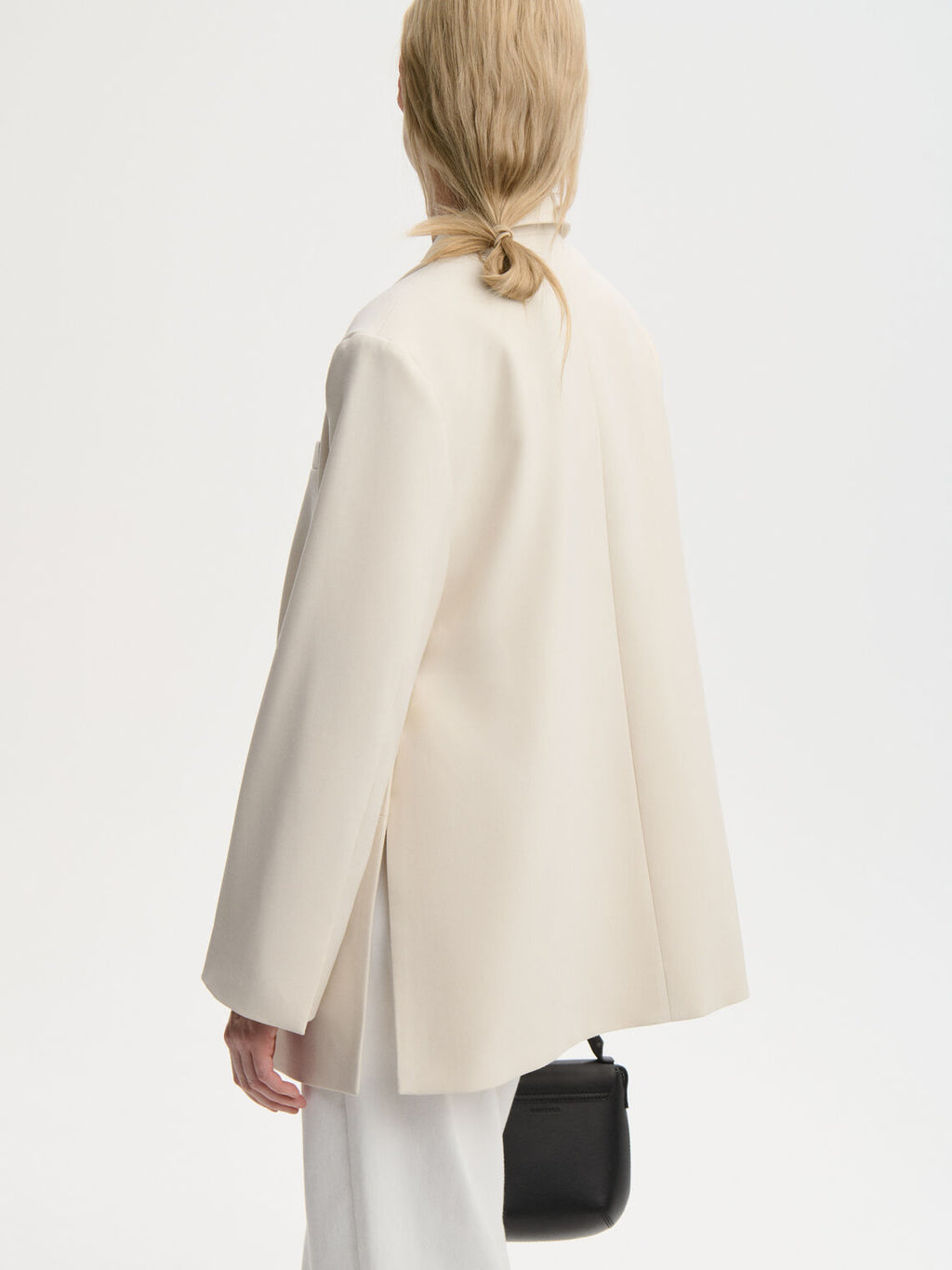 ADELE blazer fra By Malene Birger i kremhvit. Laget i resirkulert polyester og viskose med enkeltspent lukking, lommer i front, innvendig lomme, dobbel splitt bak og foret konstruksjon. Løs passform.
