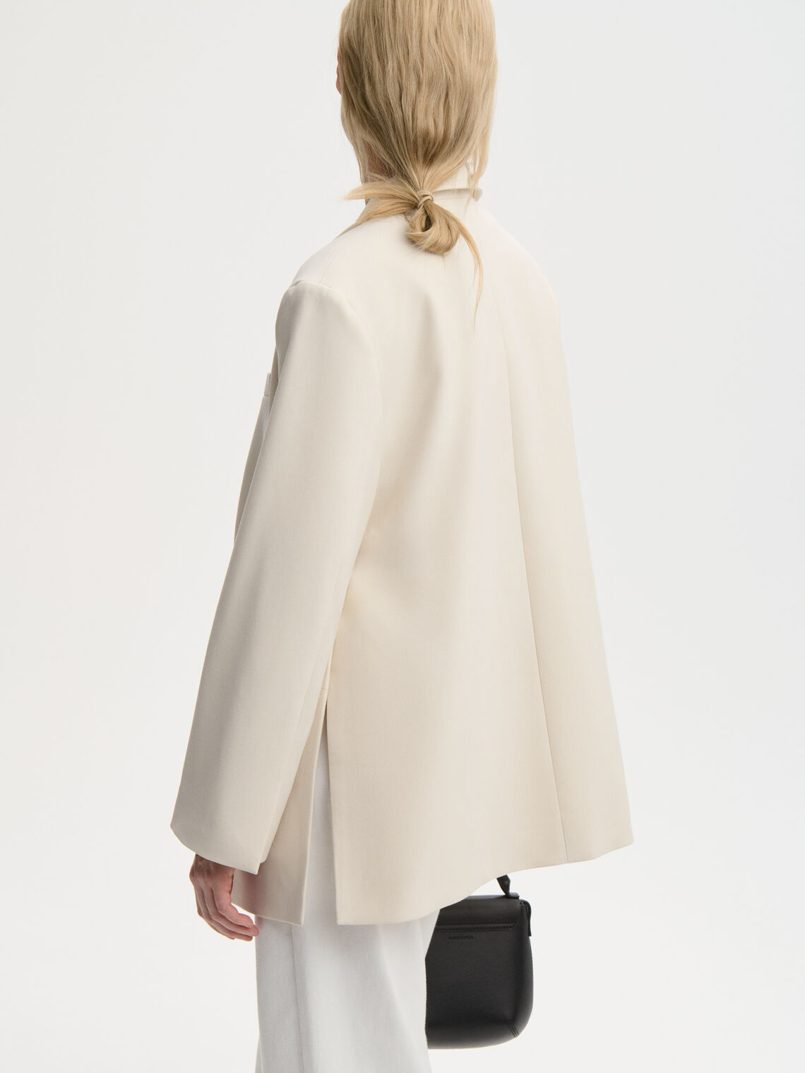 ADELE blazer fra By Malene Birger i kremhvit. Laget i resirkulert polyester og viskose med enkeltspent lukking, lommer i front, innvendig lomme, dobbel splitt bak og foret konstruksjon. Løs passform.
