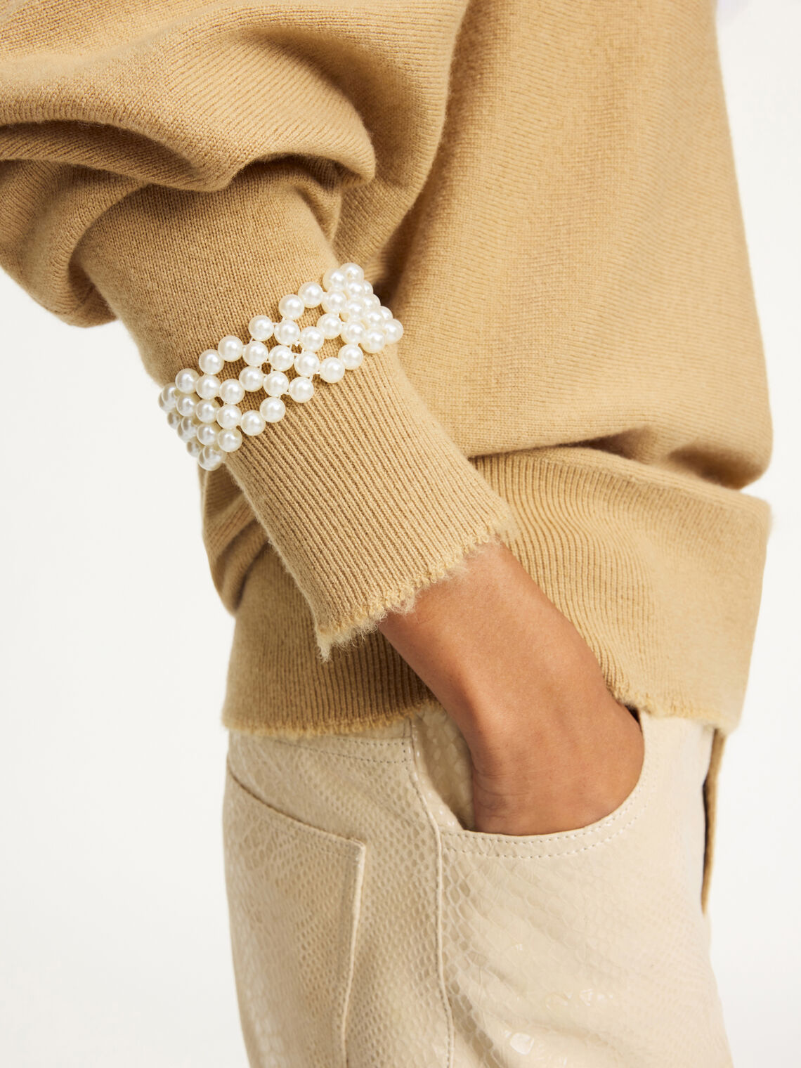 CHAKIE armbånd fra By Malene Birger i hvit. Laget i plastikk med falske perler og elastisk strikk. Feminine armbånd i onesize, selges i par.