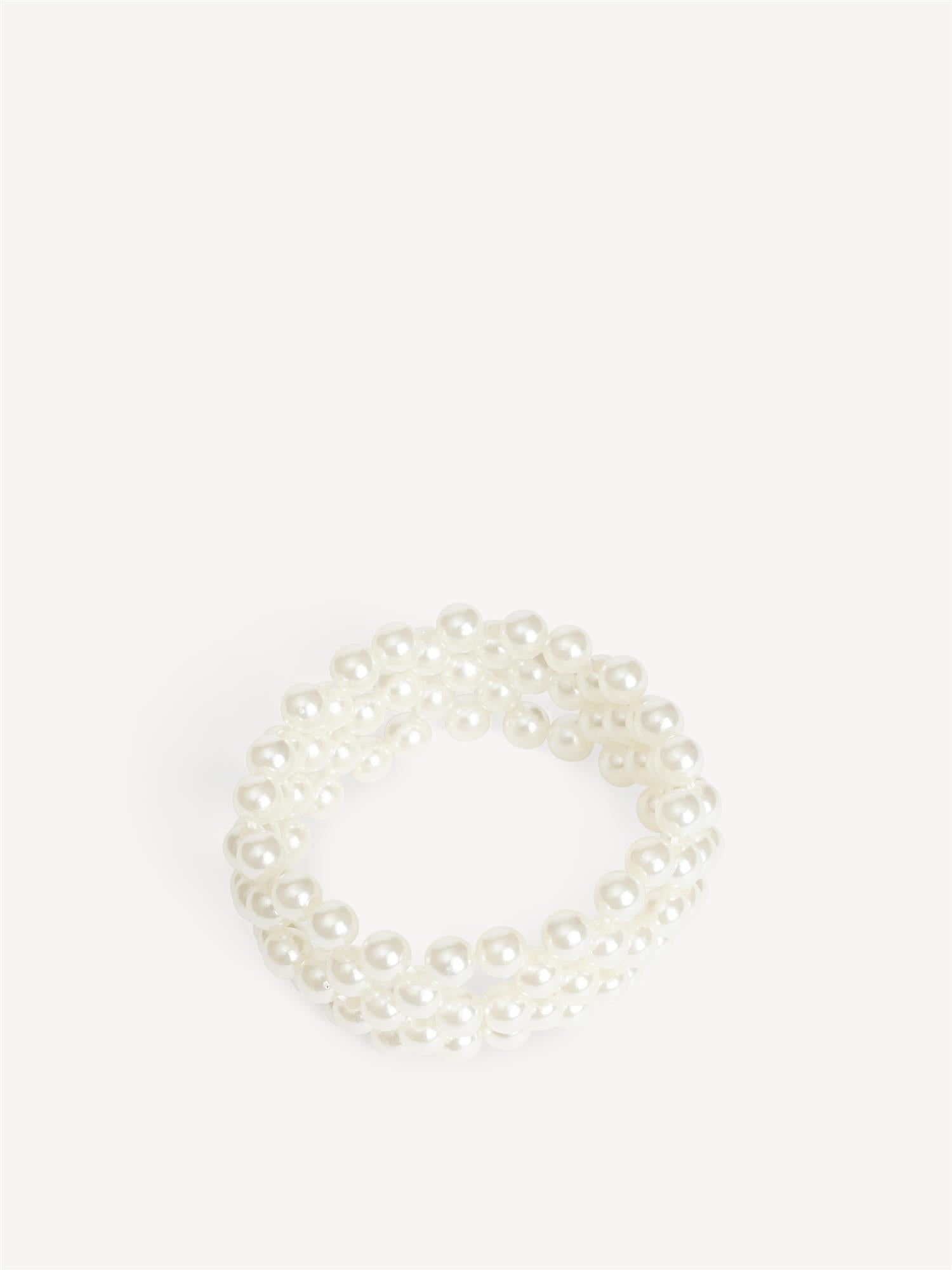 CHAKIE armbånd fra By Malene Birger i hvit. Laget i plastikk med falske perler og elastisk strikk. Feminine armbånd i onesize, selges i par.
