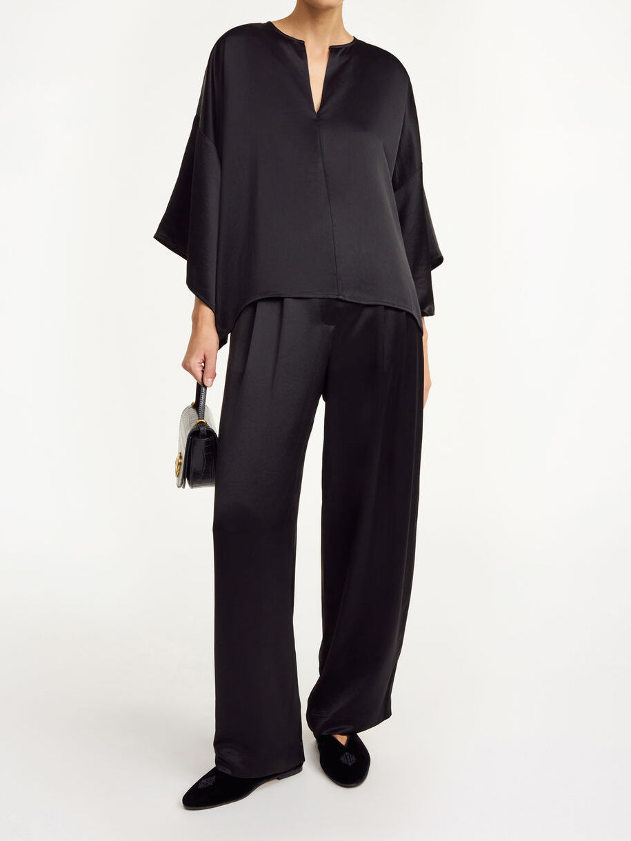 Sortfarget CICIE satengbluse fra By Malene Birger med v-utringning, albuelange løse ermer og liten hempe i halsen.
