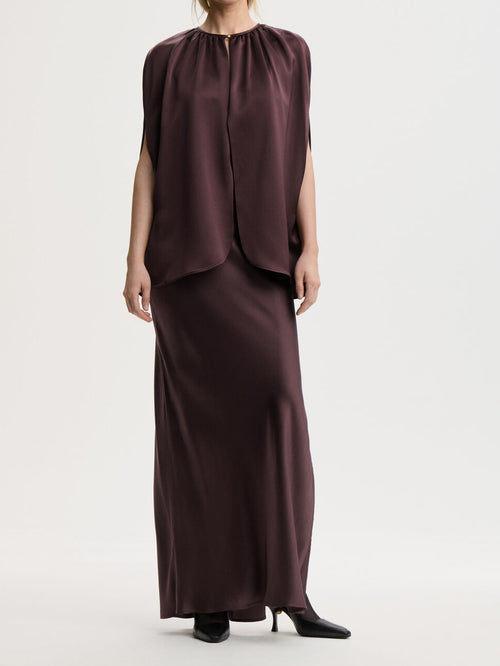 By Malene Birger DALLIAS cape i lilla satin med glatt og skinnende overflate. Rund halsringning og elegante fallende linjer.