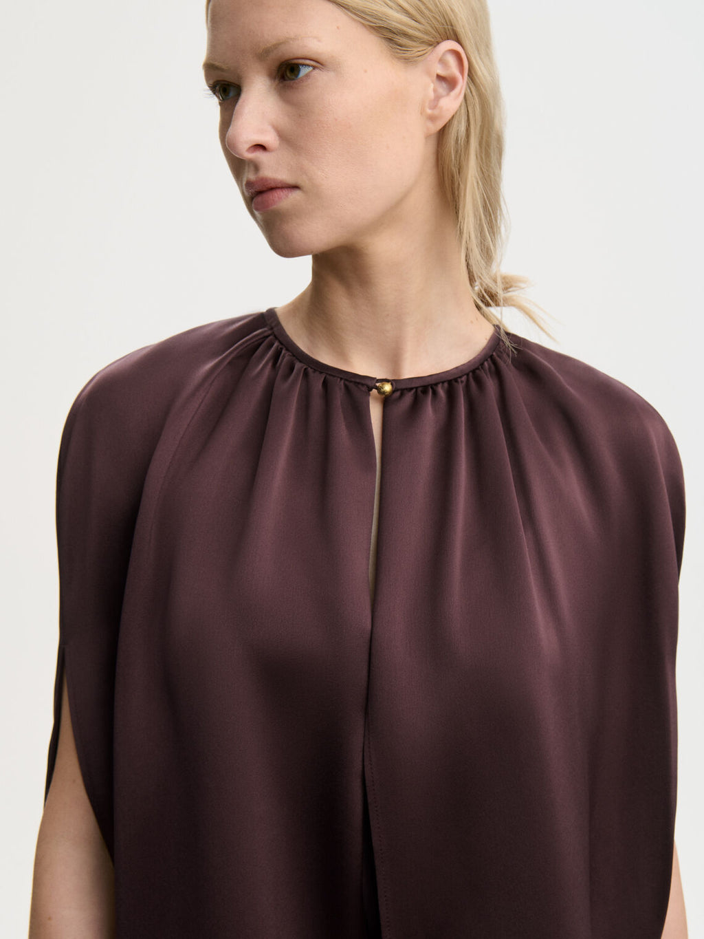By Malene Birger DALLIAS cape i lilla satin med glatt og skinnende overflate. Rund halsringning og elegante fallende linjer.