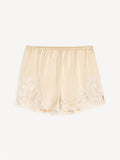 By Malene Birger ERI sateng shorts i kremfarget acetat med blonde-detaljer langs kanten, elastisk linning og lommer i siden.