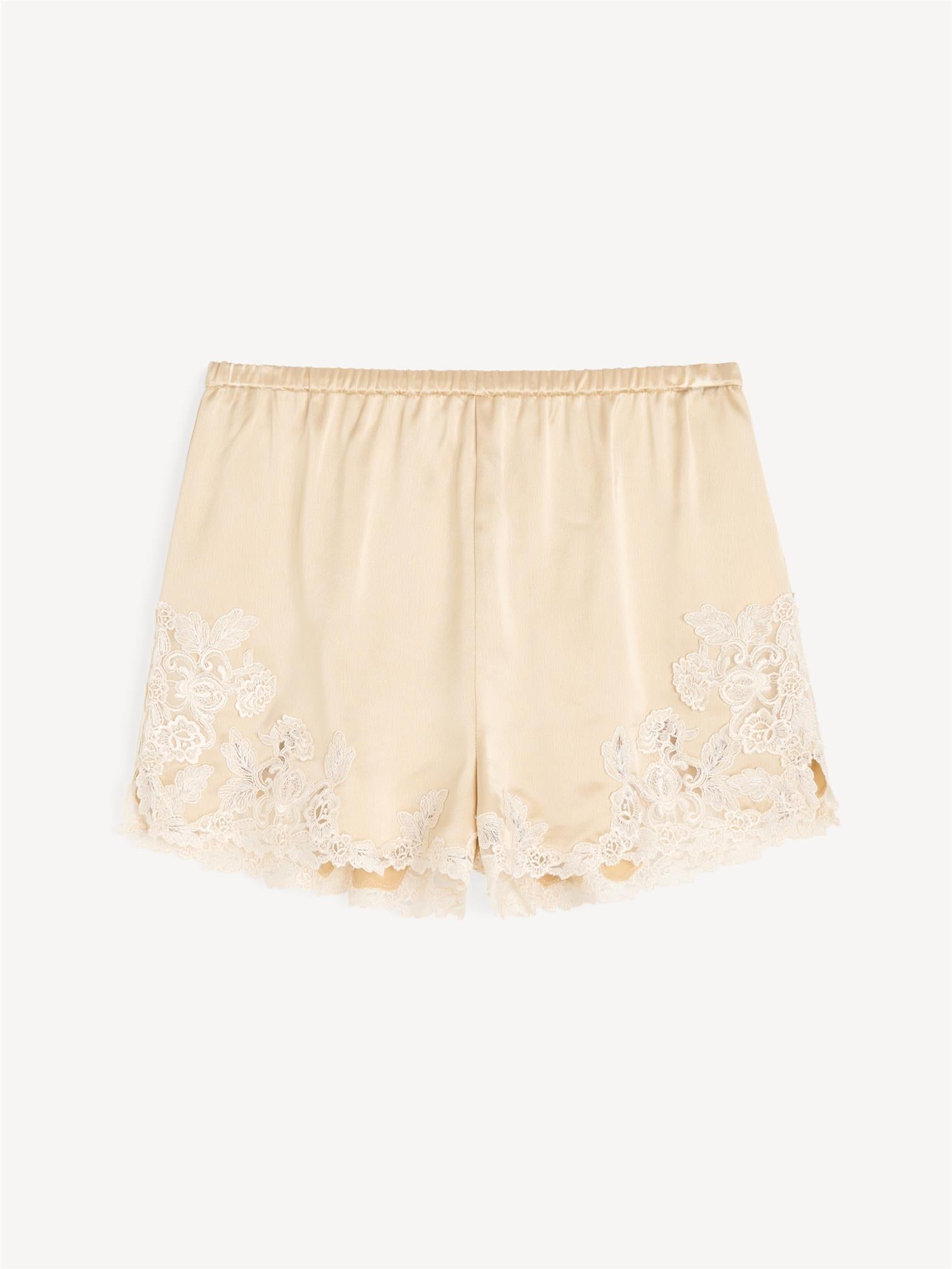 By Malene Birger ERI sateng shorts i kremfarget acetat med blonde-detaljer langs kanten, elastisk linning og lommer i siden.