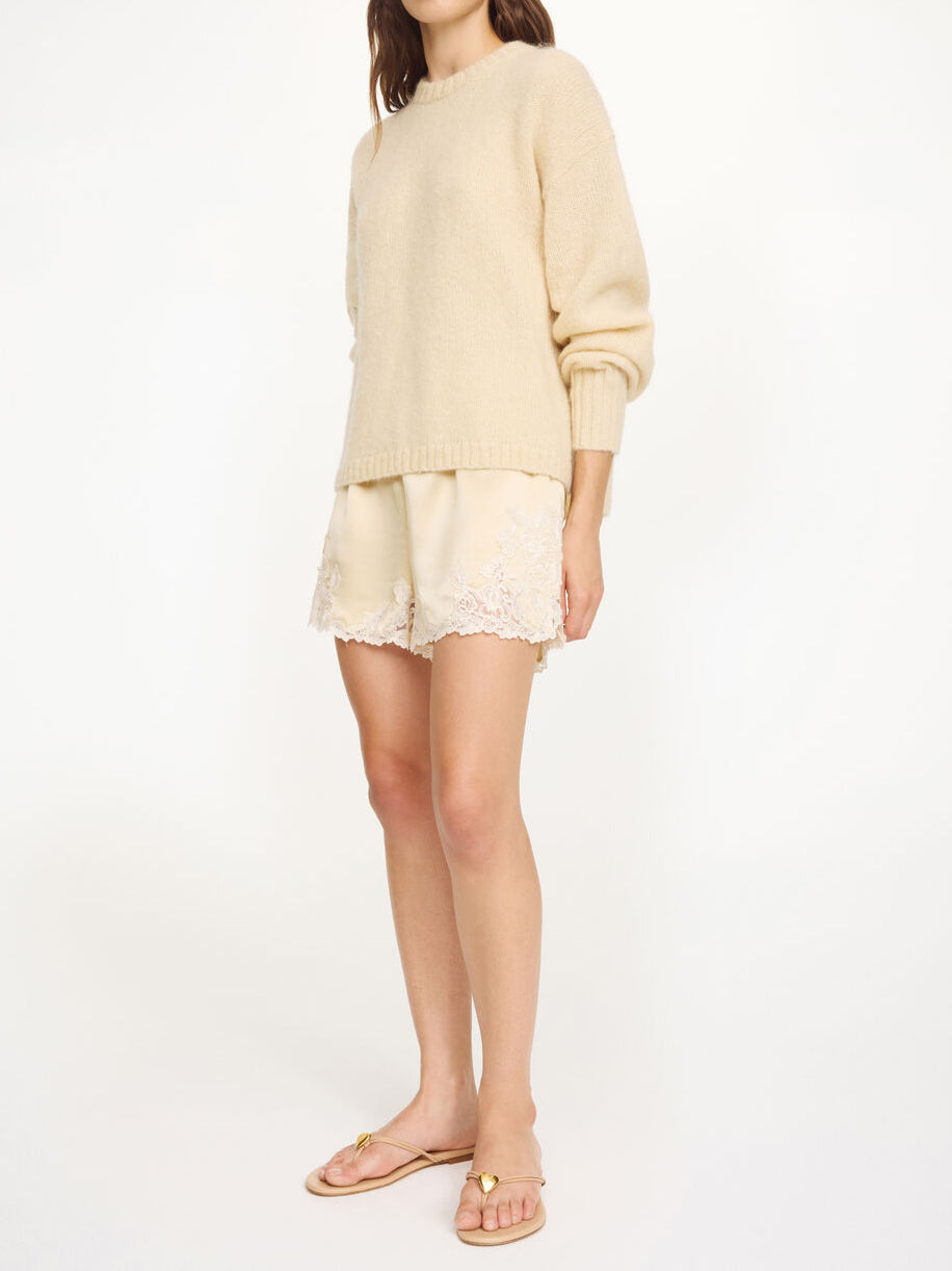 By Malene Birger ERI sateng shorts i kremfarget acetat med blonde-detaljer langs kanten, elastisk linning og lommer i siden.