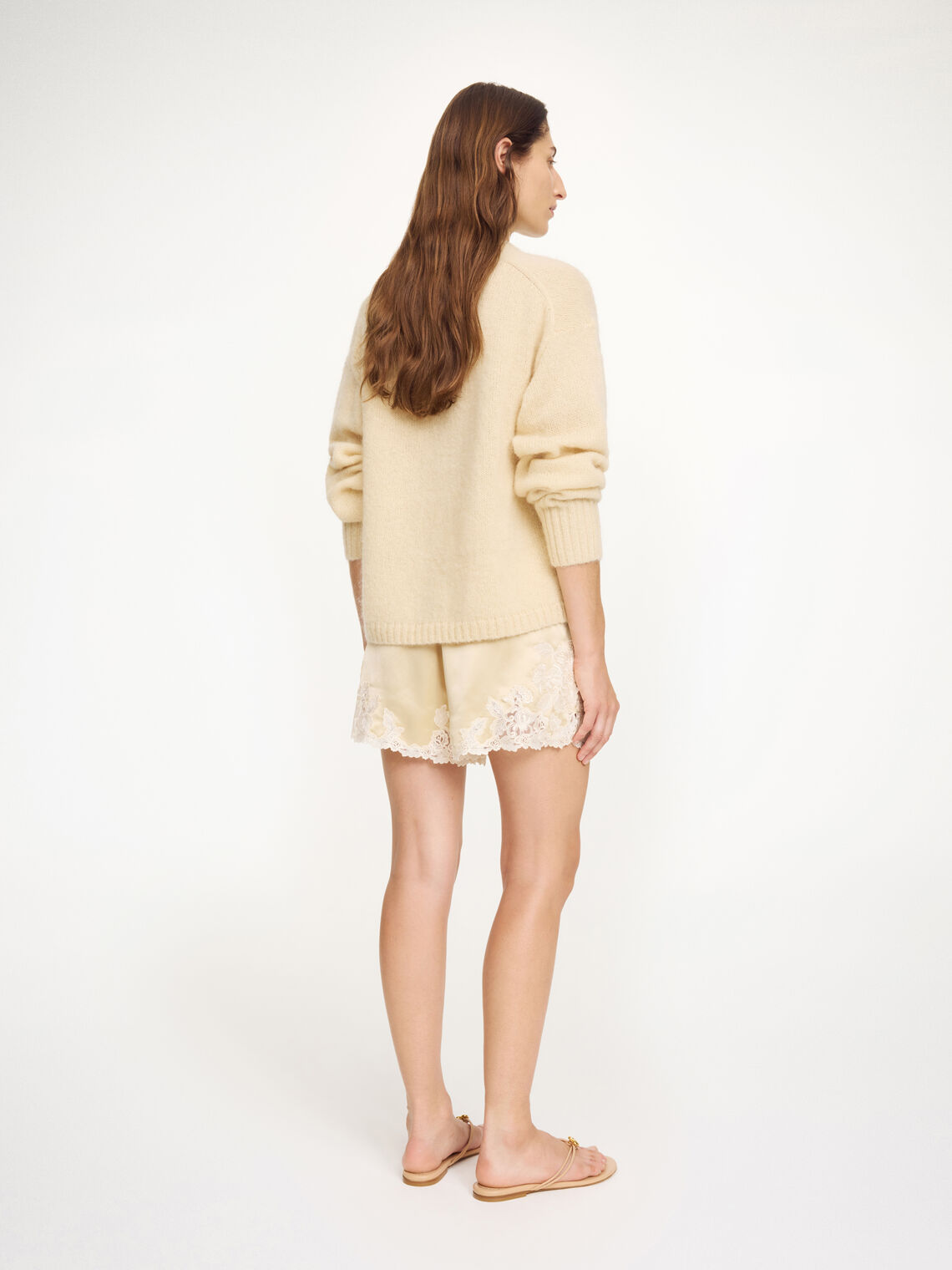 By Malene Birger ERI sateng shorts i kremfarget acetat med blonde-detaljer langs kanten, elastisk linning og lommer i siden.