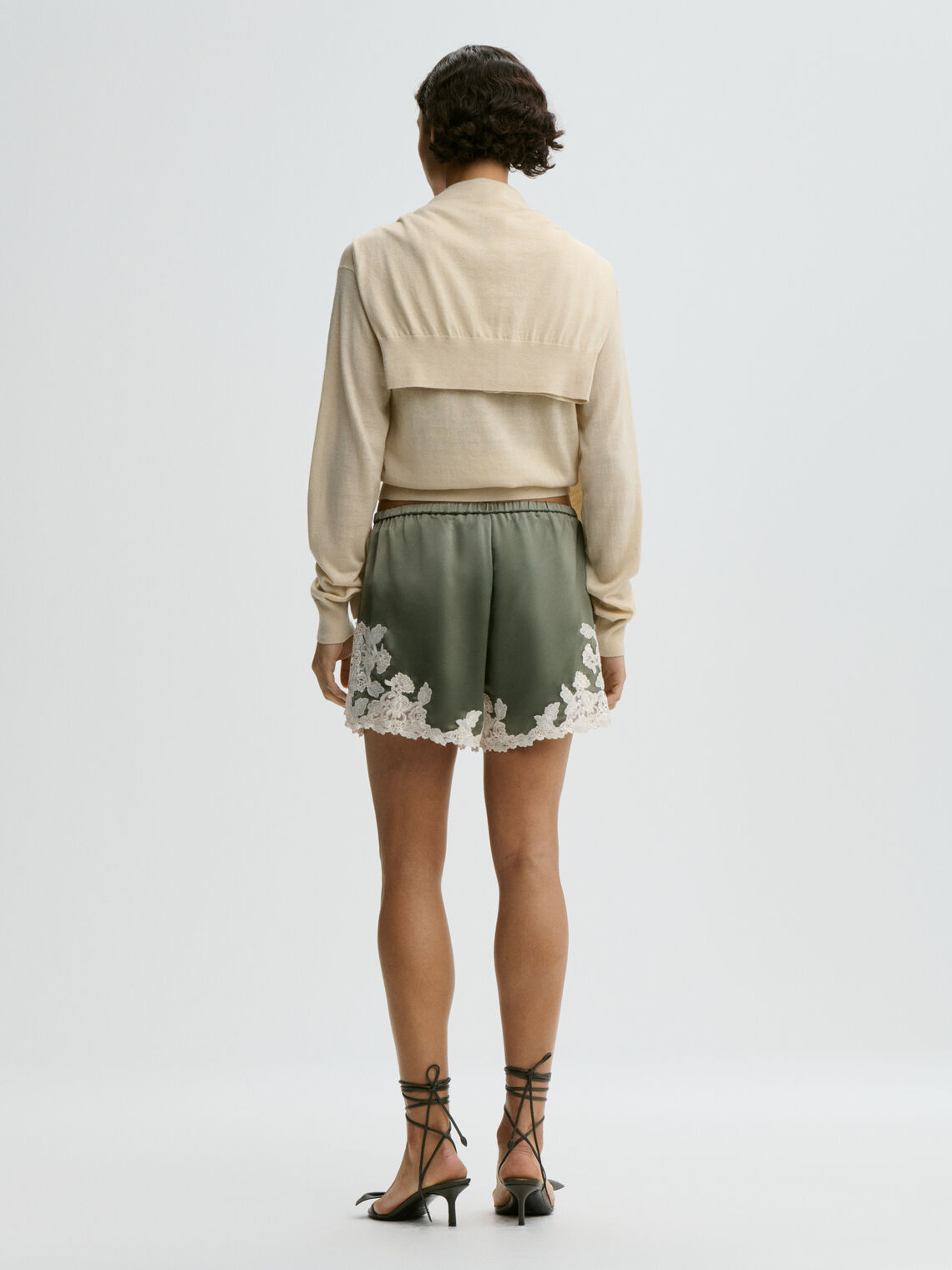 By Malene Birger ERI sateng shorts i olivengrønn acetat med blonde-detaljer langs kanten, elastisk linning og lommer i siden.