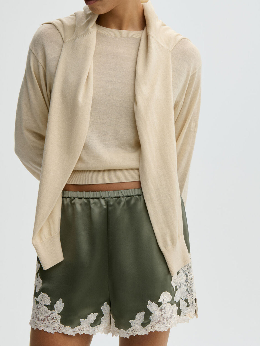 By Malene Birger ERI sateng shorts i olivengrønn acetat med blonde-detaljer langs kanten, elastisk linning og lommer i siden.