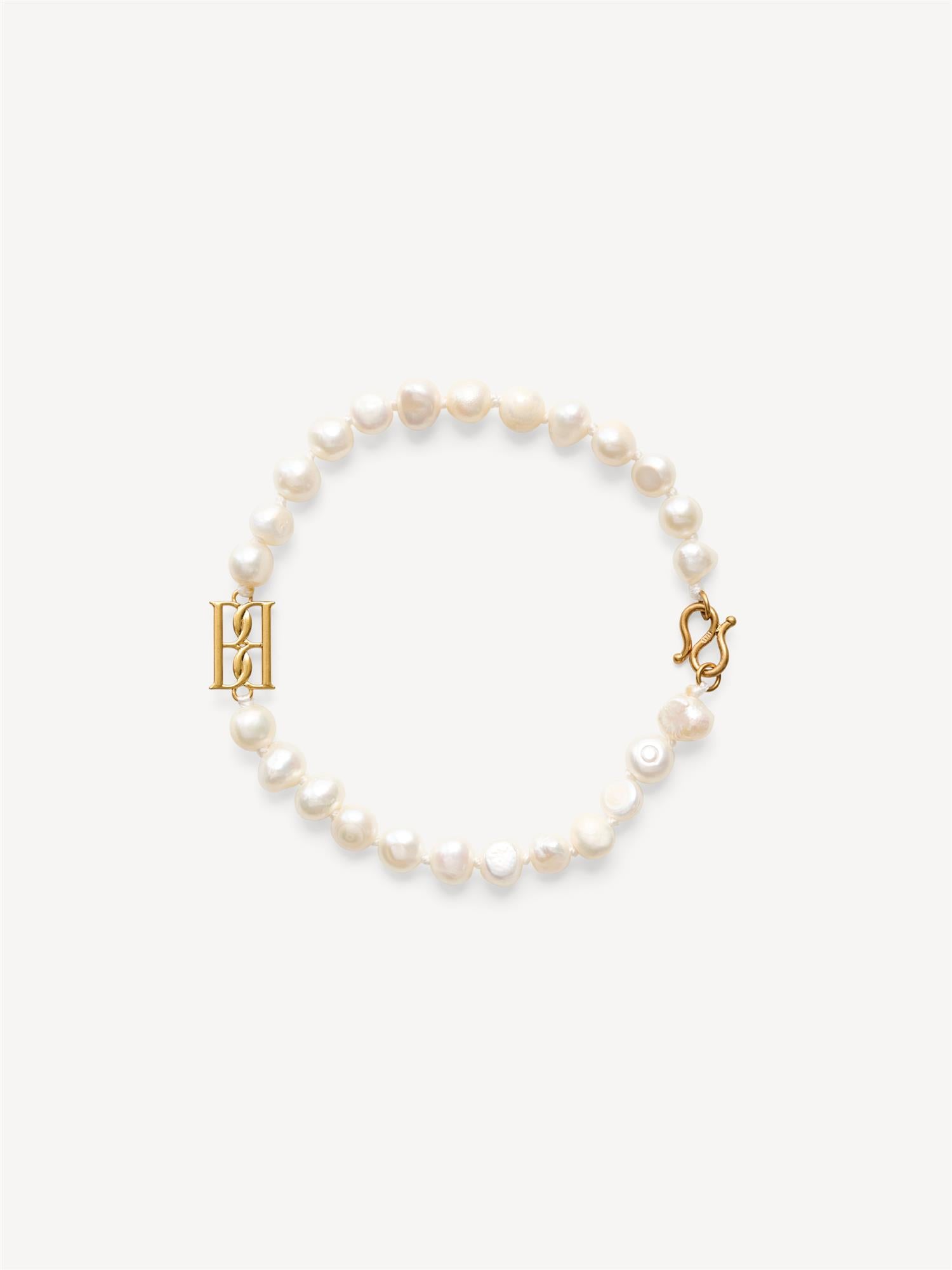 By Malene Birger Herlas fotlenke i hvite ferskvannsperler med monogram, 25 cm lang, lukkes med S-krok.