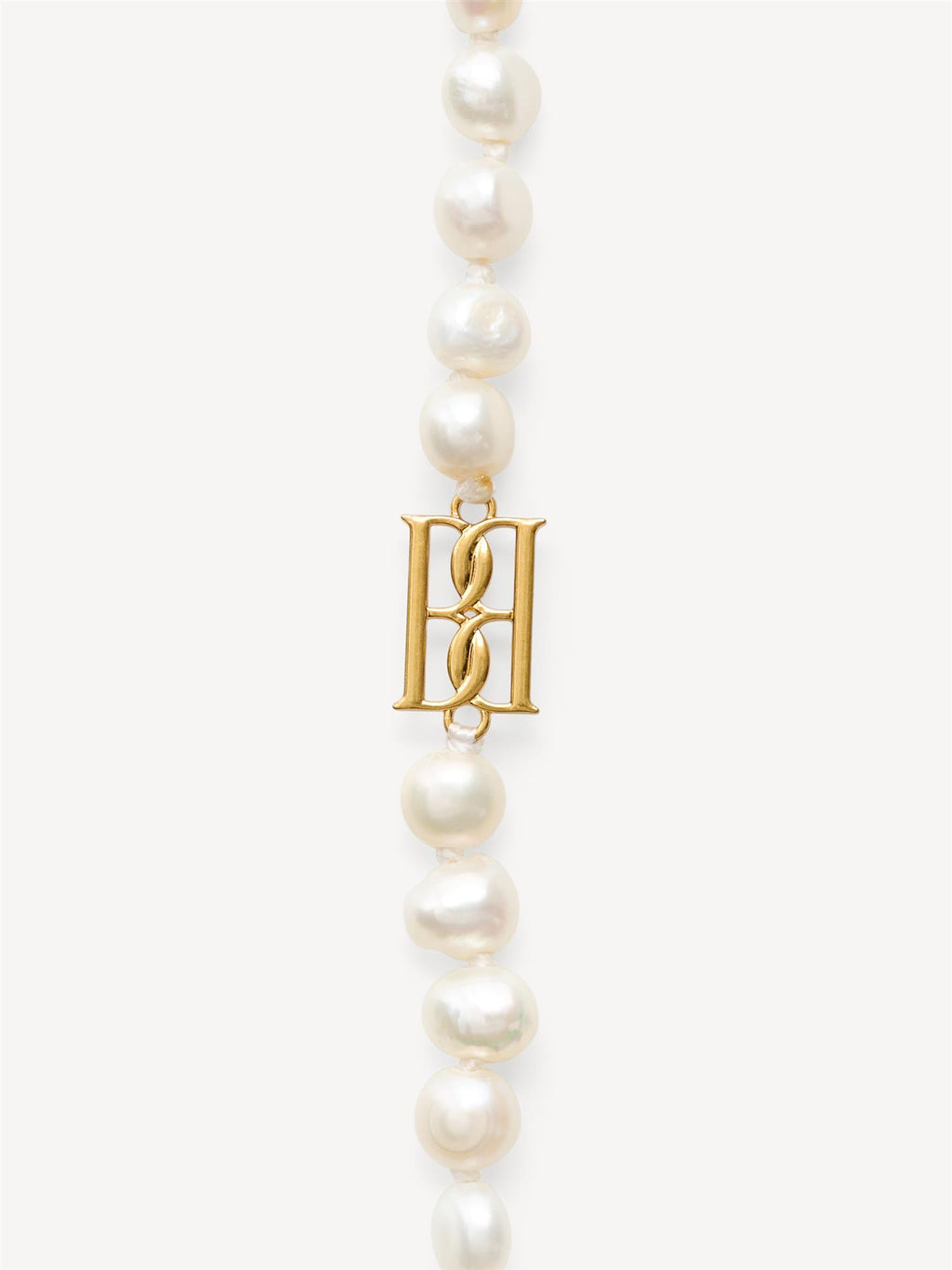 By Malene Birger Herlas fotlenke i hvite ferskvannsperler med monogram, 25 cm lang, lukkes med S-krok.