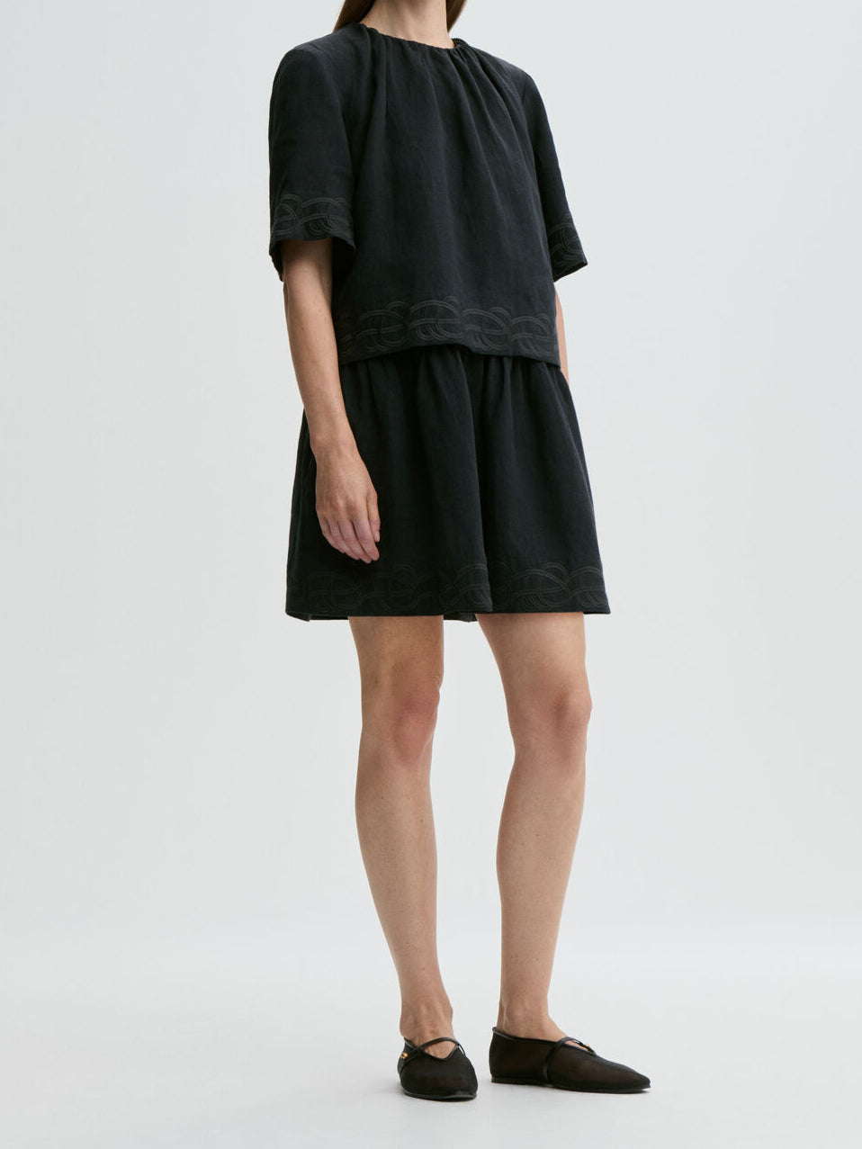 By Malene Birger Jania kjole i sort 100% lin med rund hals, knapplukking i nakken og swirl-broderi.