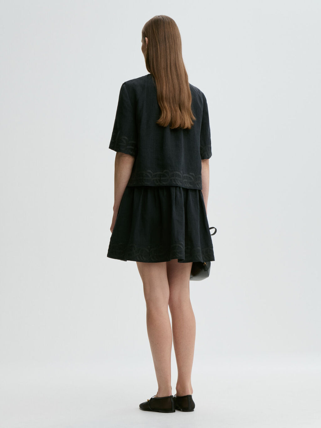 By Malene Birger Jania kjole i sort 100% lin med rund hals, knapplukking i nakken og swirl-broderi.