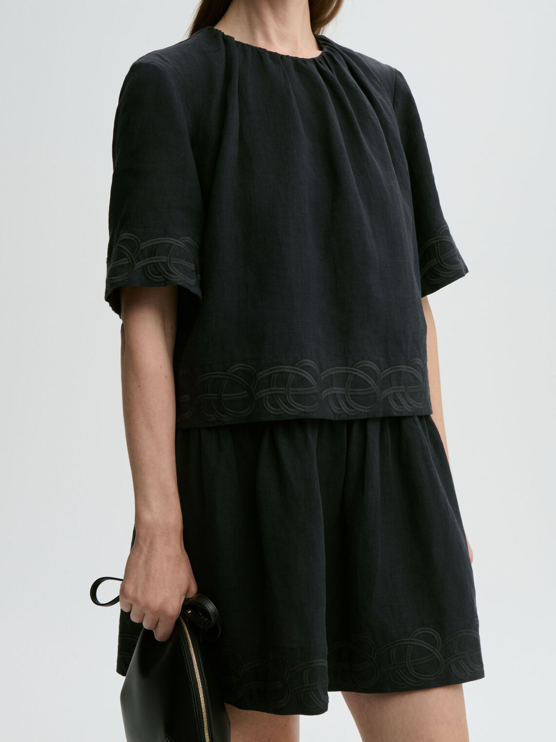 By Malene Birger Jania kjole i sort 100% lin med rund hals, knapplukking i nakken og swirl-broderi.