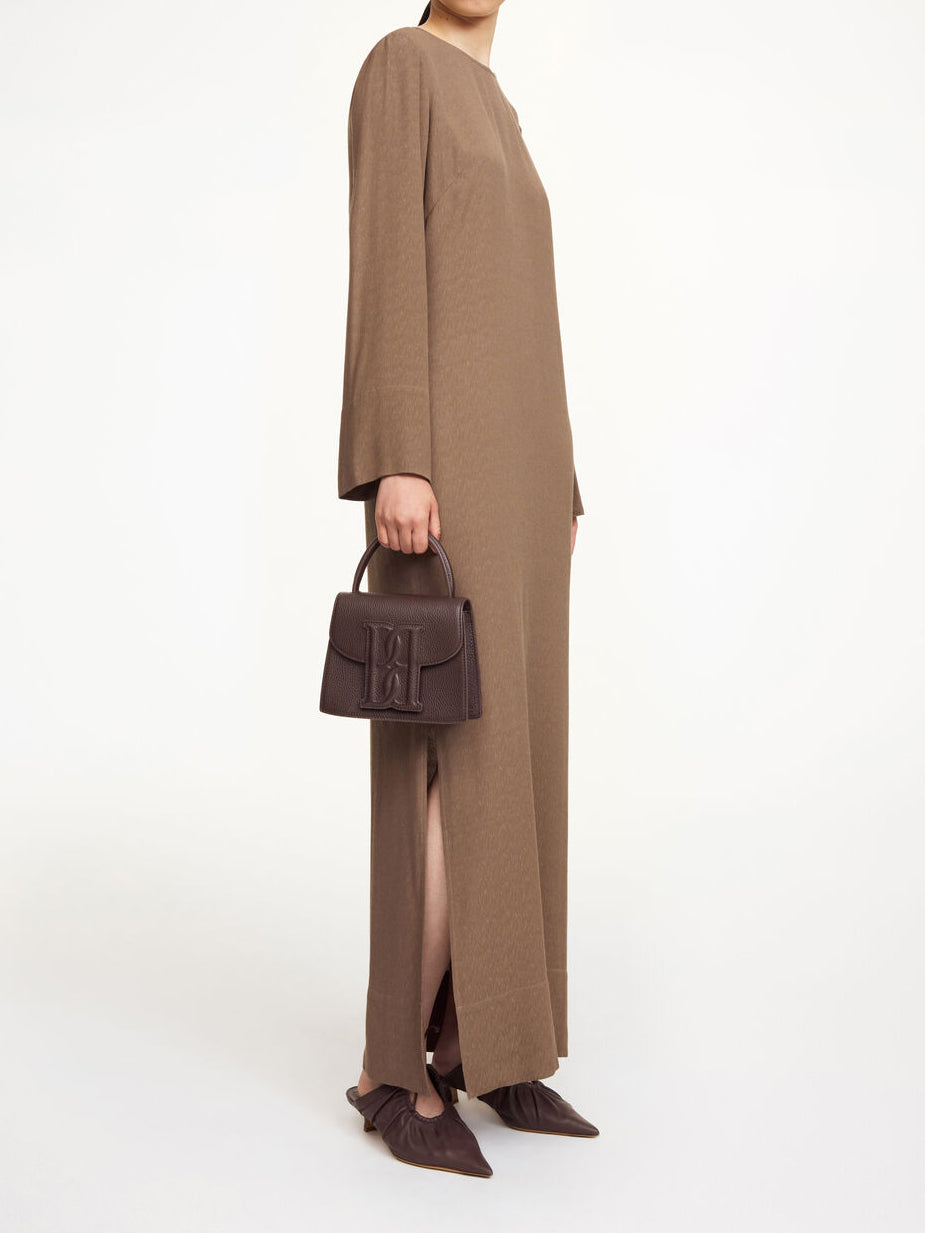 By Malene Birger Kallas lang kjole i brun viskose med rund hals, lange ermer, glidelås og splitt i siden.