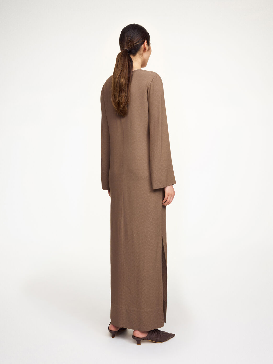 By Malene Birger Kallas lang kjole i brun viskose med rund hals, lange ermer, glidelås og splitt i siden.