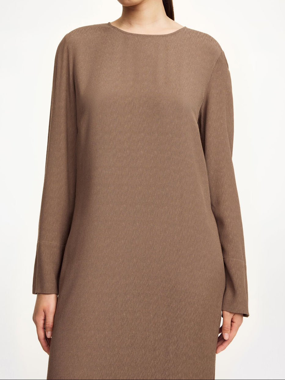 By Malene Birger Kallas lang kjole i brun viskose med rund hals, lange ermer, glidelås og splitt i siden.
