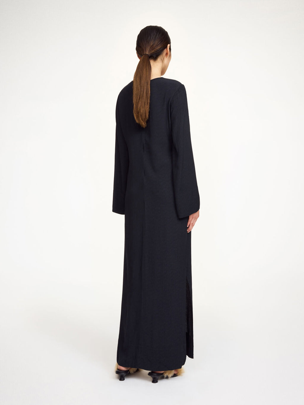 By Malene Birger Kallas lang kjole i sort viskose med rund hals, lange ermer, glidelås og splitt i siden.