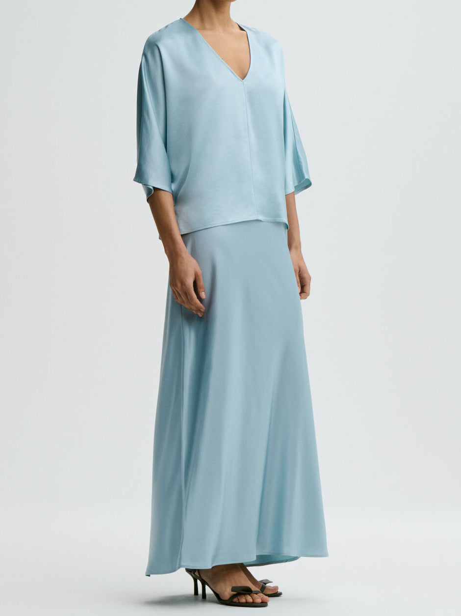 Lyseblå LUCIA bluse fra By Malene Birger, sett forfra med løs passform og splitt i siden.