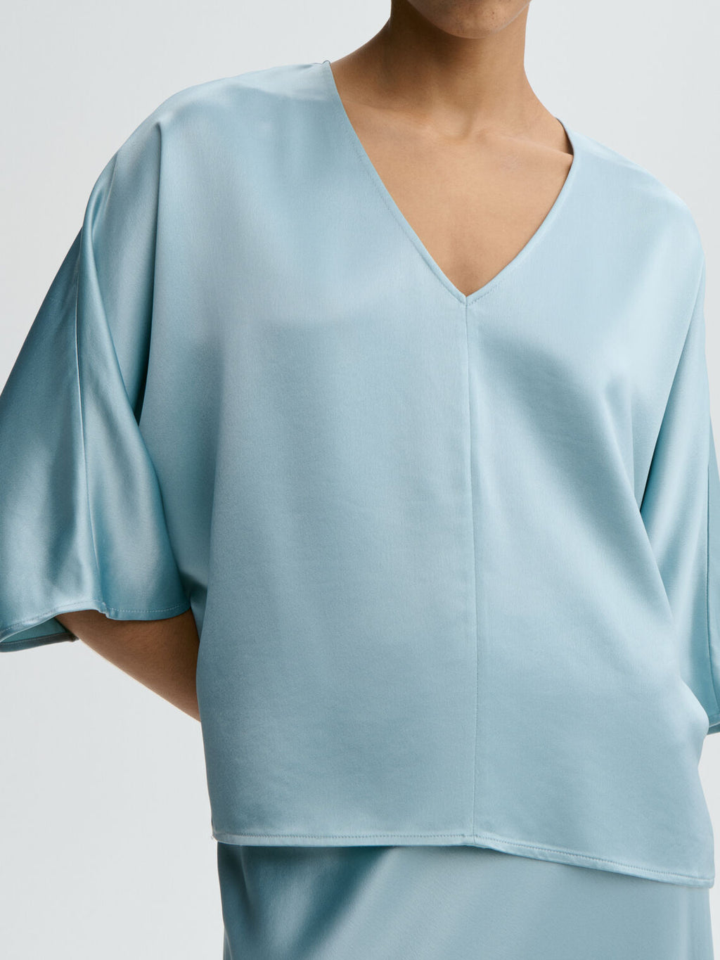 Lyseblå LUCIA satengbluse fra By Malene Birger, detaljbilde av acetat-stoff og splitt i siden.