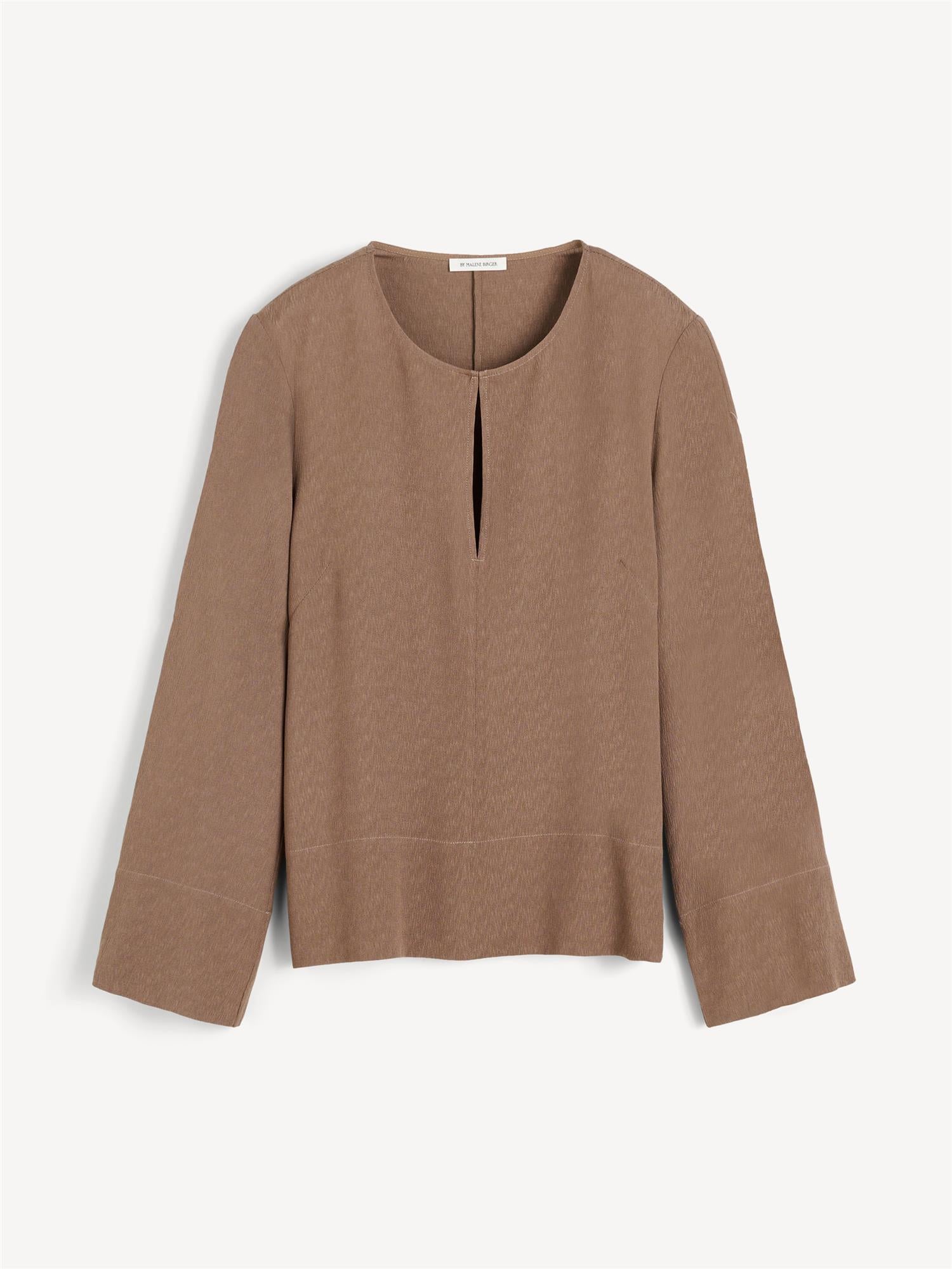 Brun MALUKKA bluse fra By Malene Birger i viskose med v-utringning, hempe i halsen, splitt i siden og rette løse ermer.