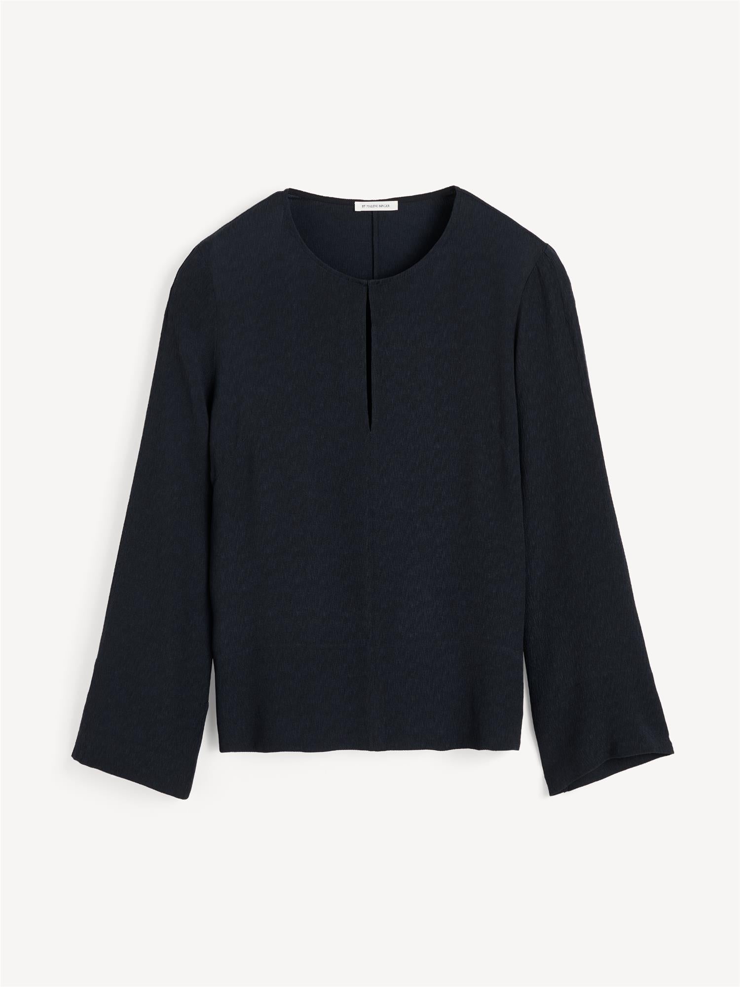 Sort MALUKKA bluse fra By Malene Birger i viskose med v-utringning, hempe i halsen, splitt i siden og rette løse ermer.
