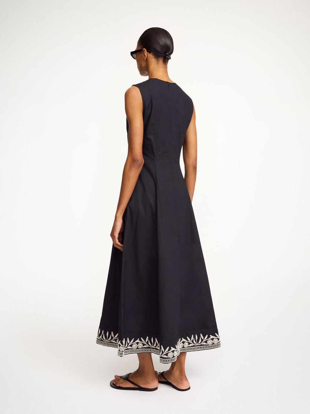 By Malene Birger Margrethe kjole i sort organisk bomull med v-utrigning, innsvinget midje og broderte detaljer.