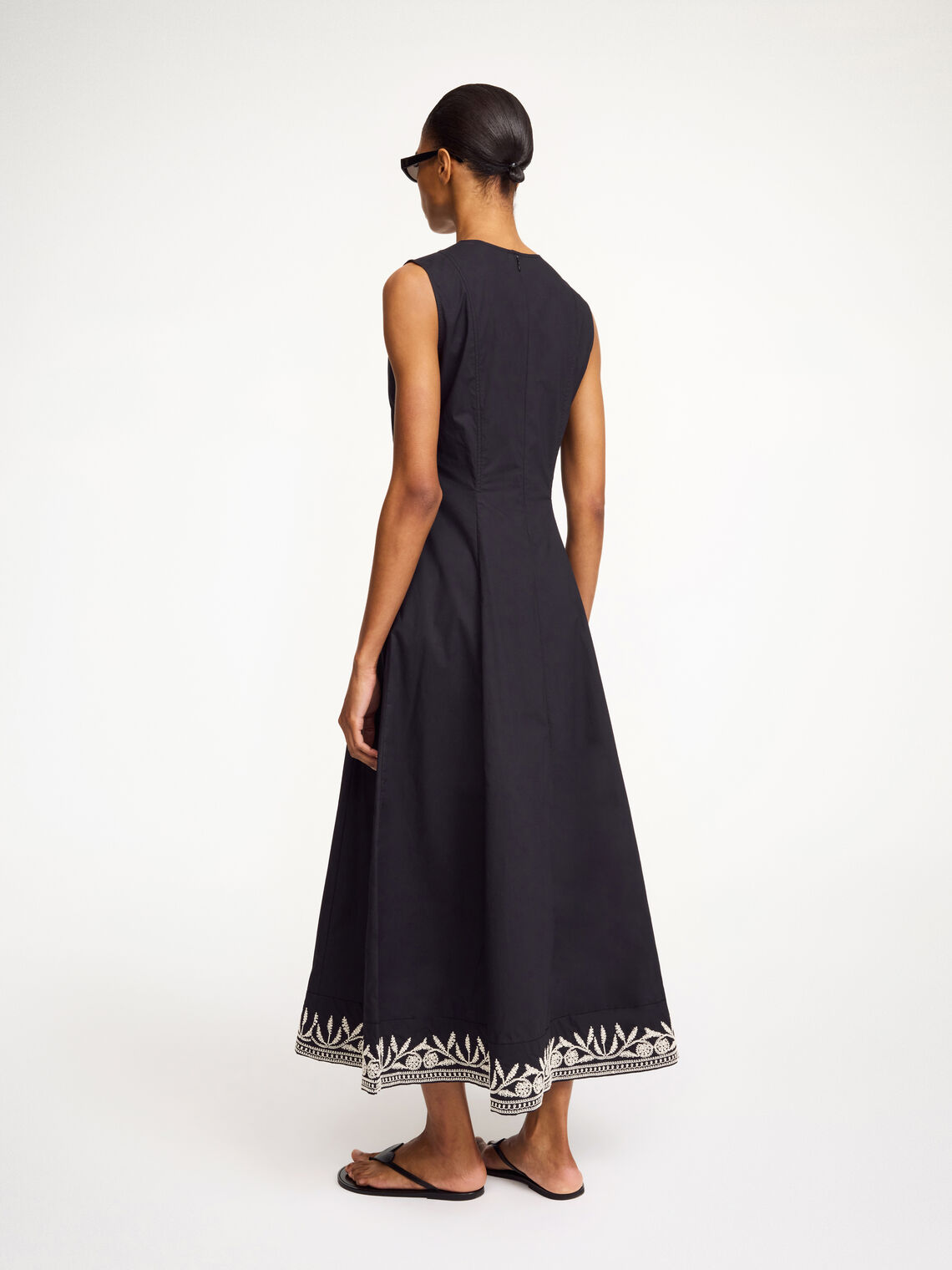 By Malene Birger Margrethe kjole i sort organisk bomull med v-utrigning, innsvinget midje og broderte detaljer.