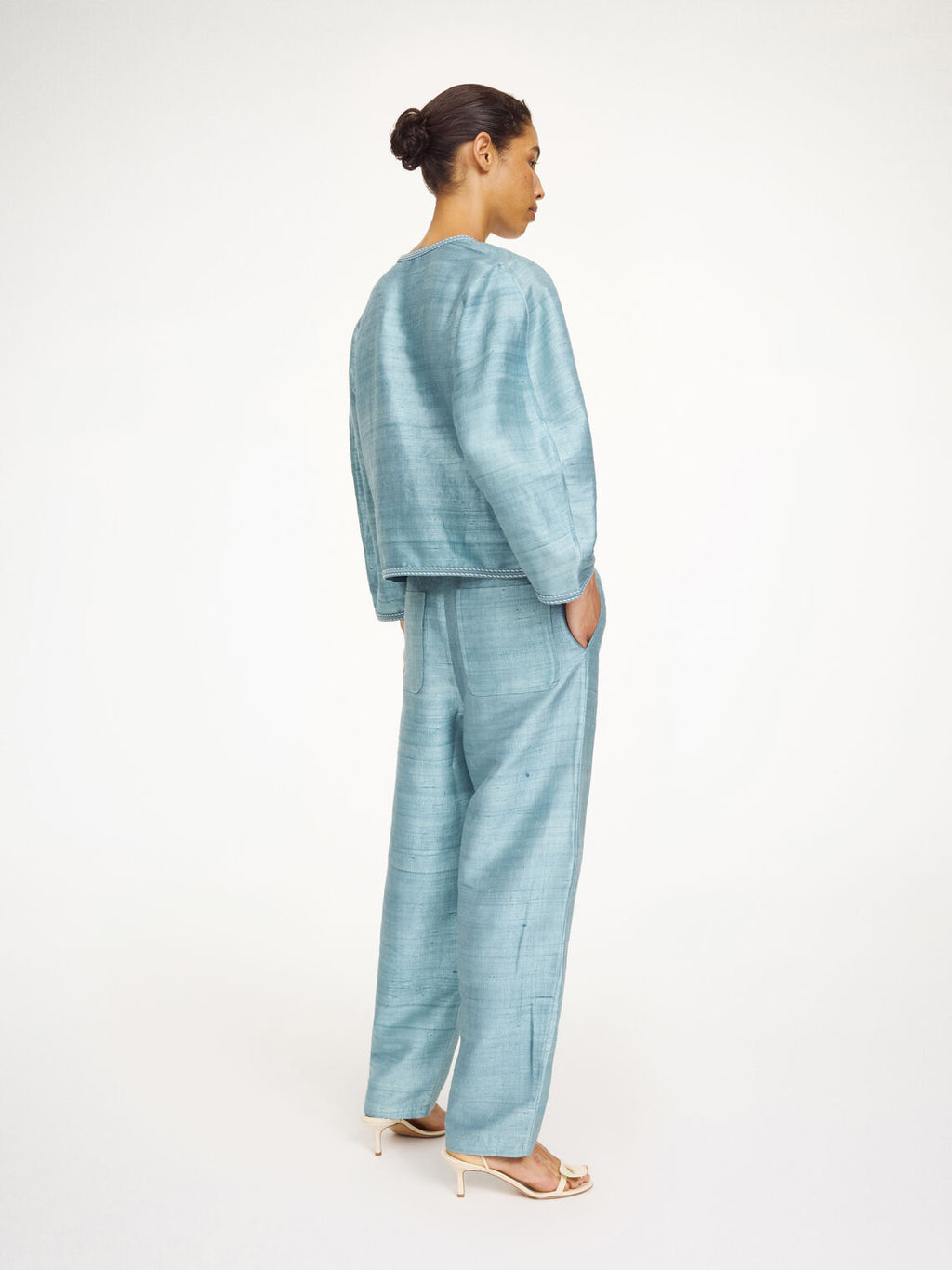 Lyseblå MINEAS bluse fra By Malene Birger i thai silke, sett bakfra med løs passform.