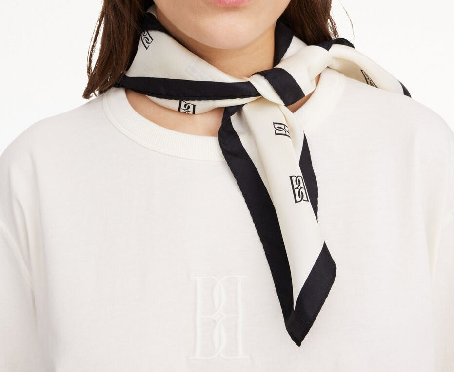 By Malene Birger MONNIS silkeskjerf i hvit med BB-monogram-print. Glatt og lett tekstur med klassisk rektangulær form.