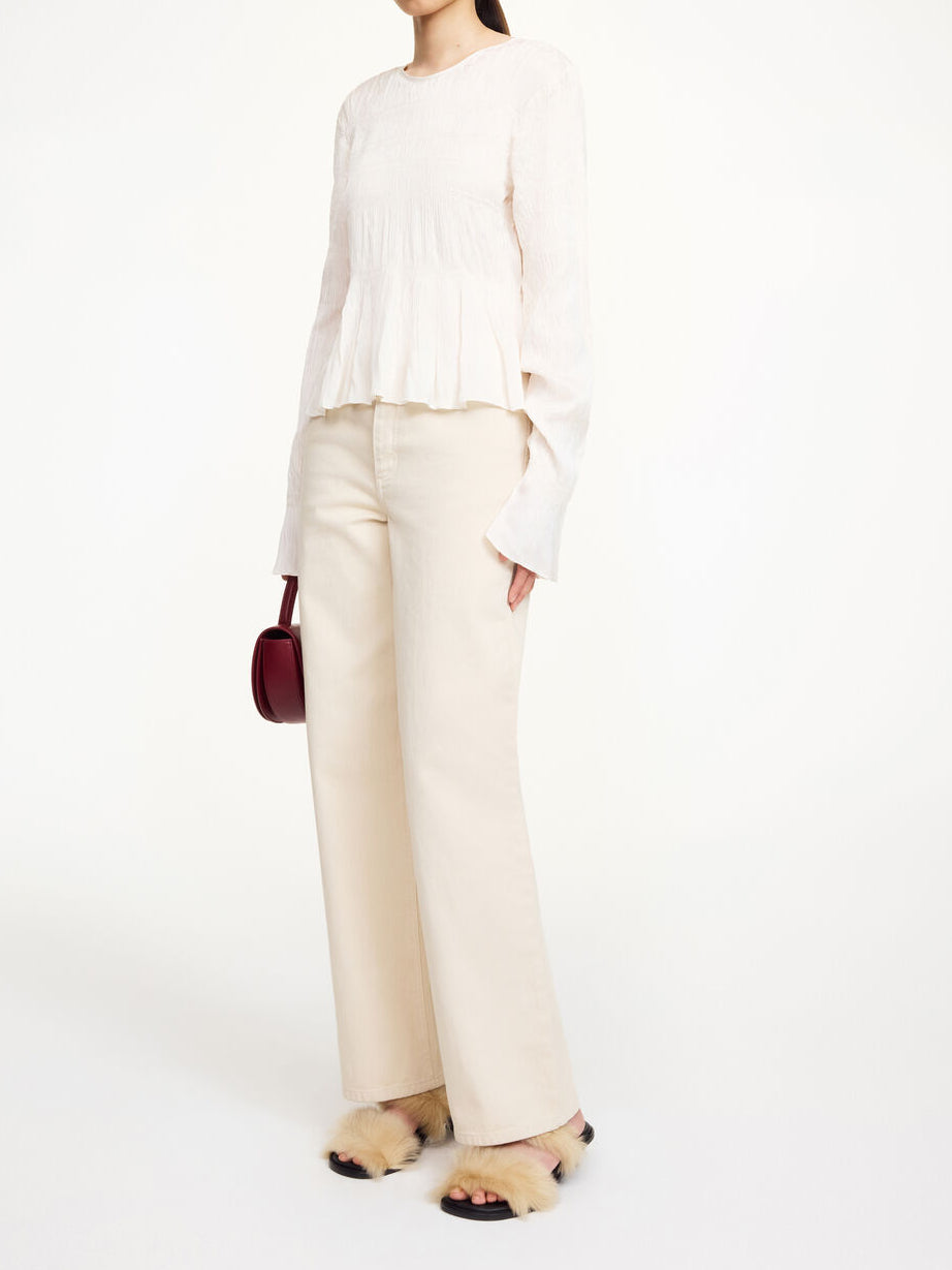Hvit OVAS bluse fra By Malene Birger, sett bakfra med dyp v-utringning og knyting i nakken.