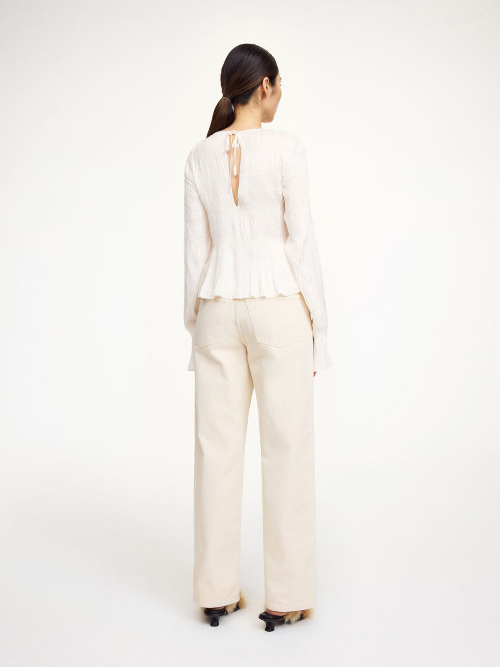 Hvit OVAS bluse fra By Malene Birger i viskose med lange ermer og peplumkant nederst.