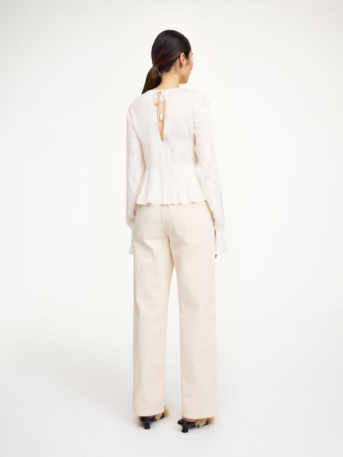 Hvit OVAS bluse fra By Malene Birger i viskose med lange ermer og peplumkant nederst.