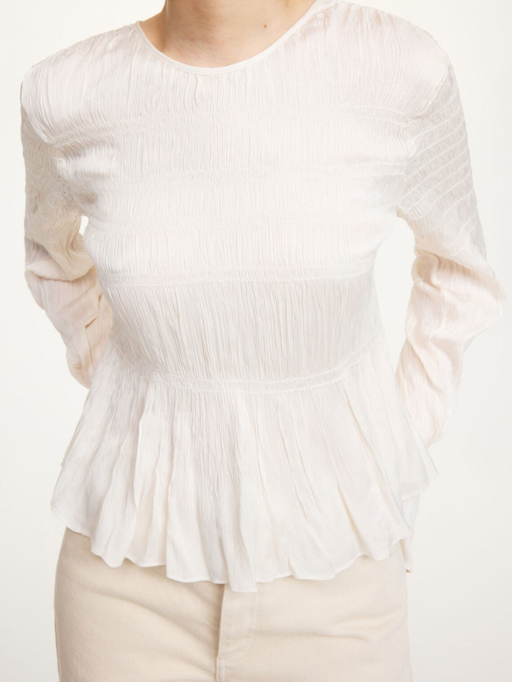 Detaljbilde av hvit OVAS bluse fra By Malene Birger med strukturstoff og knyting i ryggen.