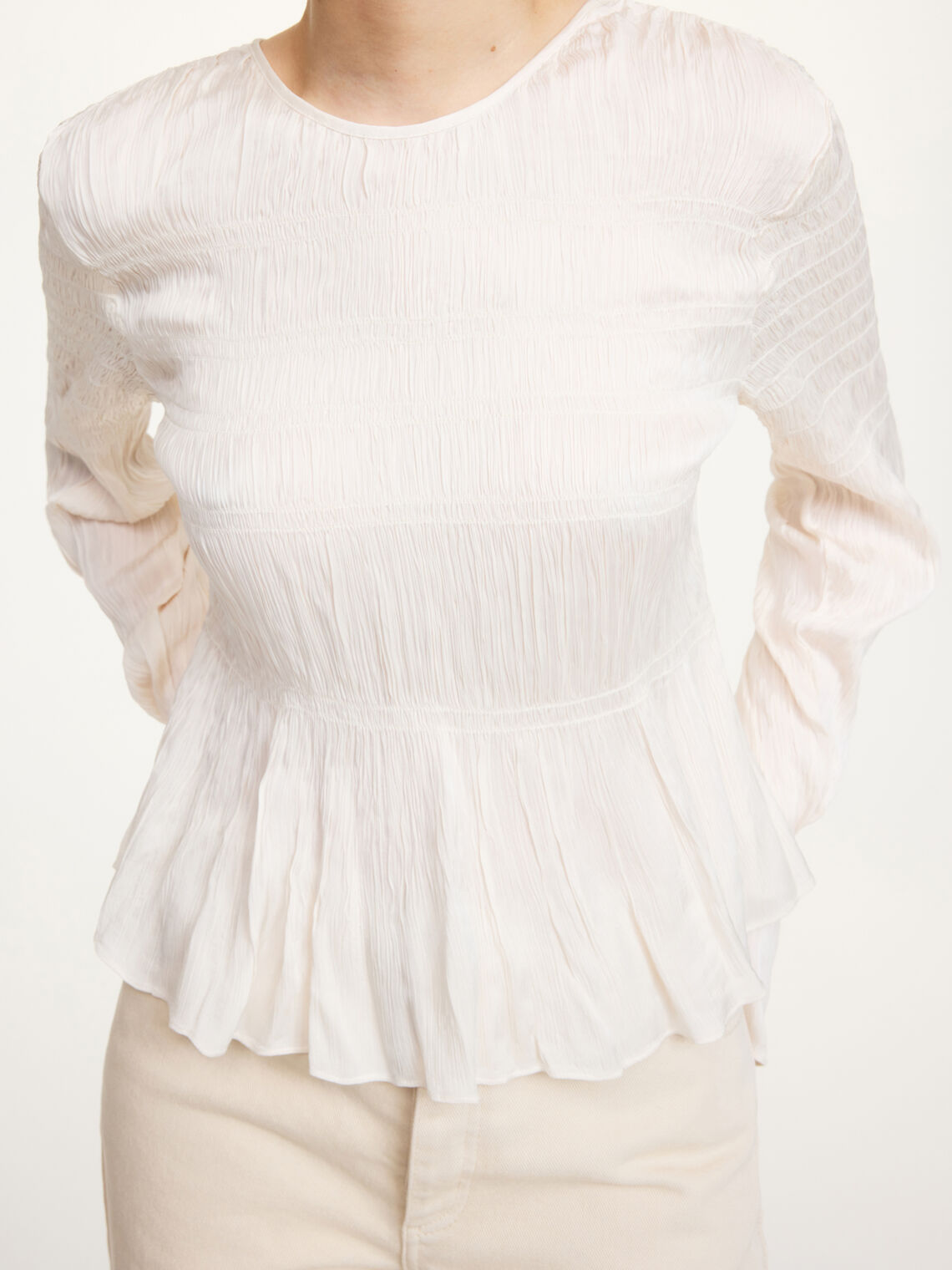Detaljbilde av hvit OVAS bluse fra By Malene Birger med strukturstoff og knyting i ryggen.