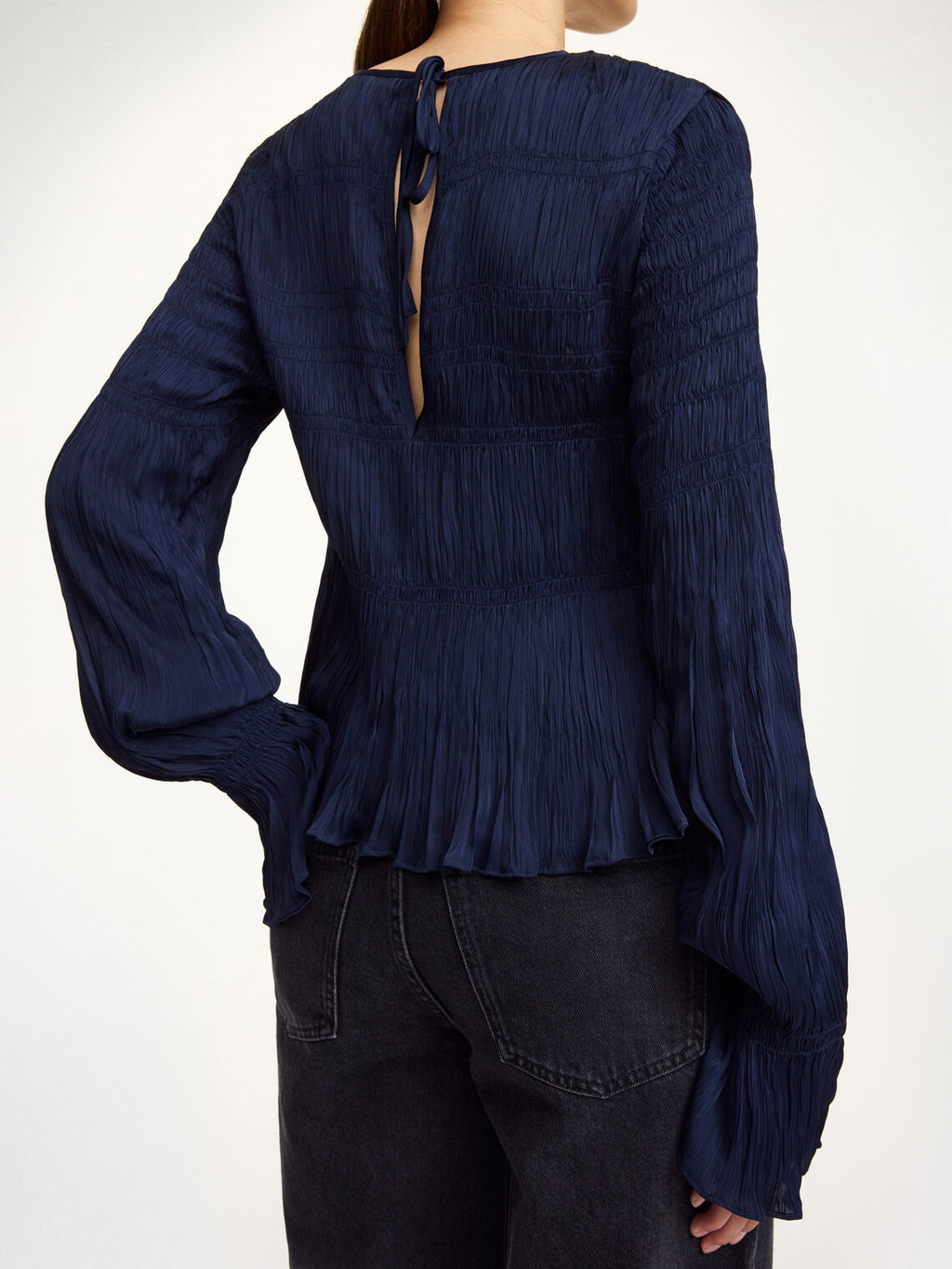 Detaljbilde av mørkeblå OVAS bluse fra By Malene Birger med strukturstoff og knyting i ryggen.