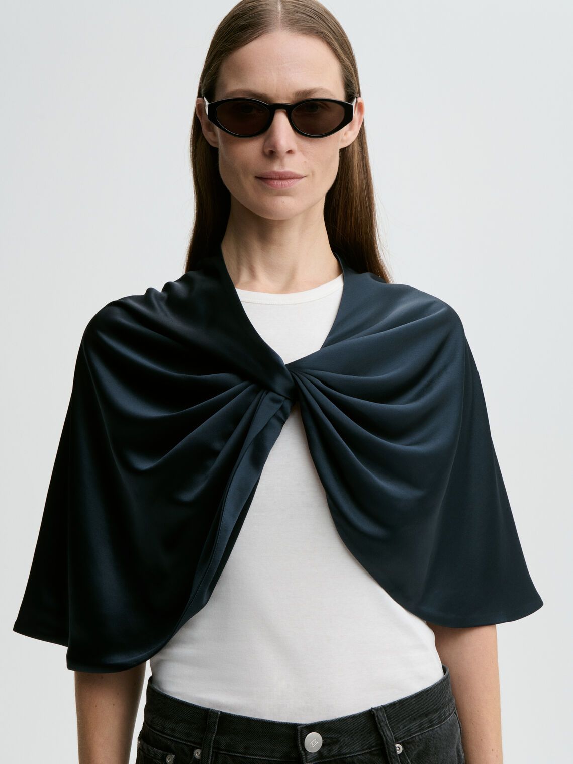 By Malene Birger PINLOS cape i mørkebla materiale med Signatur Flower-print. Rund halsringning og lange fallende linjer.