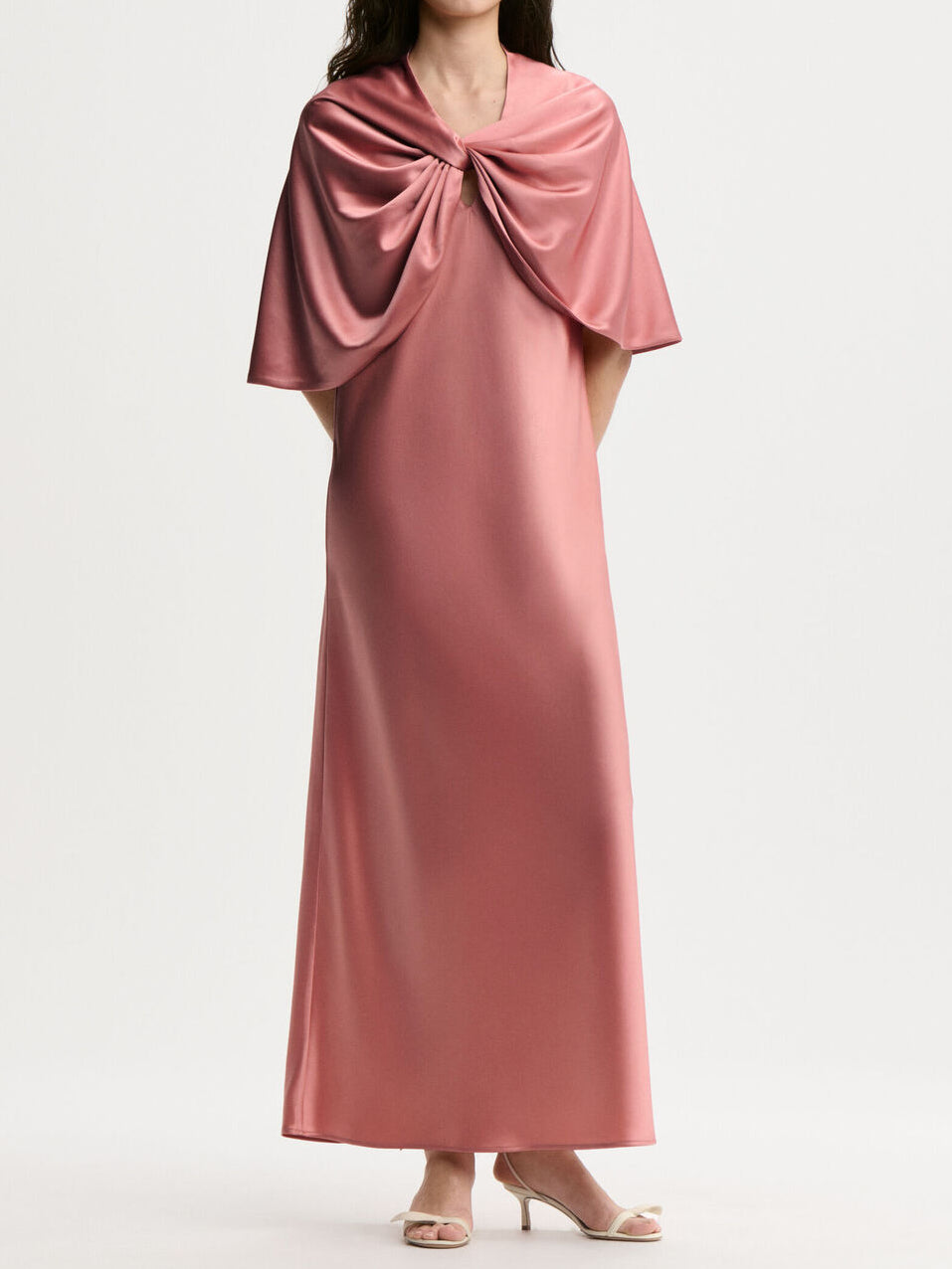 By Malene Birger PINLOS cape i rosa materiale med Signatur Flower-print. Rund halsringning og lange elegante fallende linjer.