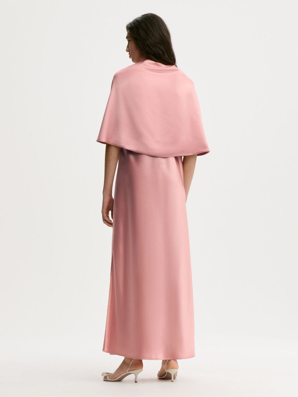 By Malene Birger PINLOS cape i rosa materiale med Signatur Flower-print. Rund halsringning og lange elegante fallende linjer.