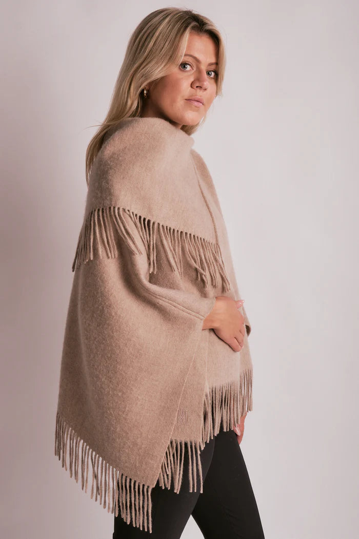 By Malene Birger TURTMA poncho i beige ull med lange frynser langs kantene. Romslig passform som kan brettes som skjerf.