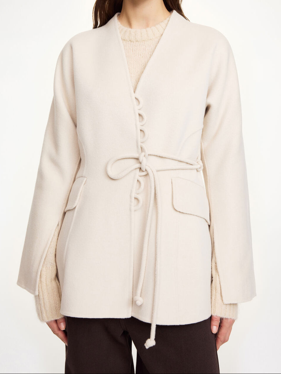 Lalou ulljakke i fargen hvit fra By Malene Birger laget i hundre prosent RWS-sertifisert ull. Jakken er en feminin variant av den klassiske blazeren med et elegant omslag som kan knytes på flere måter. Den har splitter på ermene, praktiske lommer i front og en justerbar lukking som gir et tidløst og moderne uttrykk.