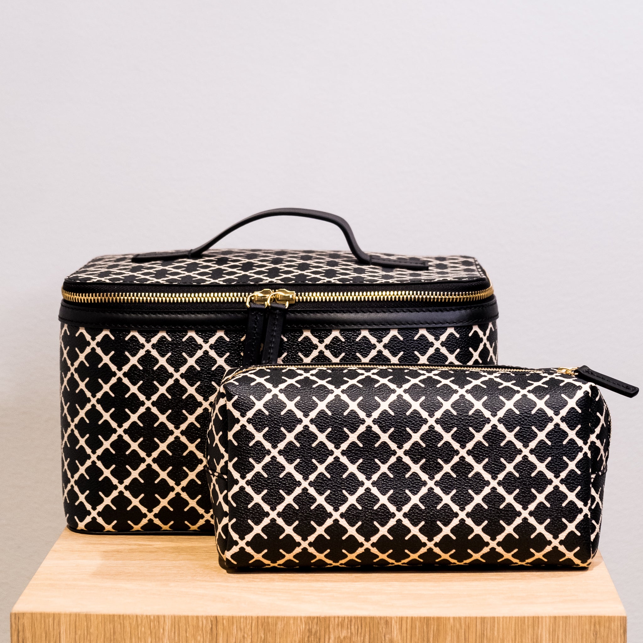 By Malene Birger Bae Beauty Box toalettmappe i sort, laget av polyvinylklorid med Signature Flower-print, med flere rom og en ekstra sminkepung.