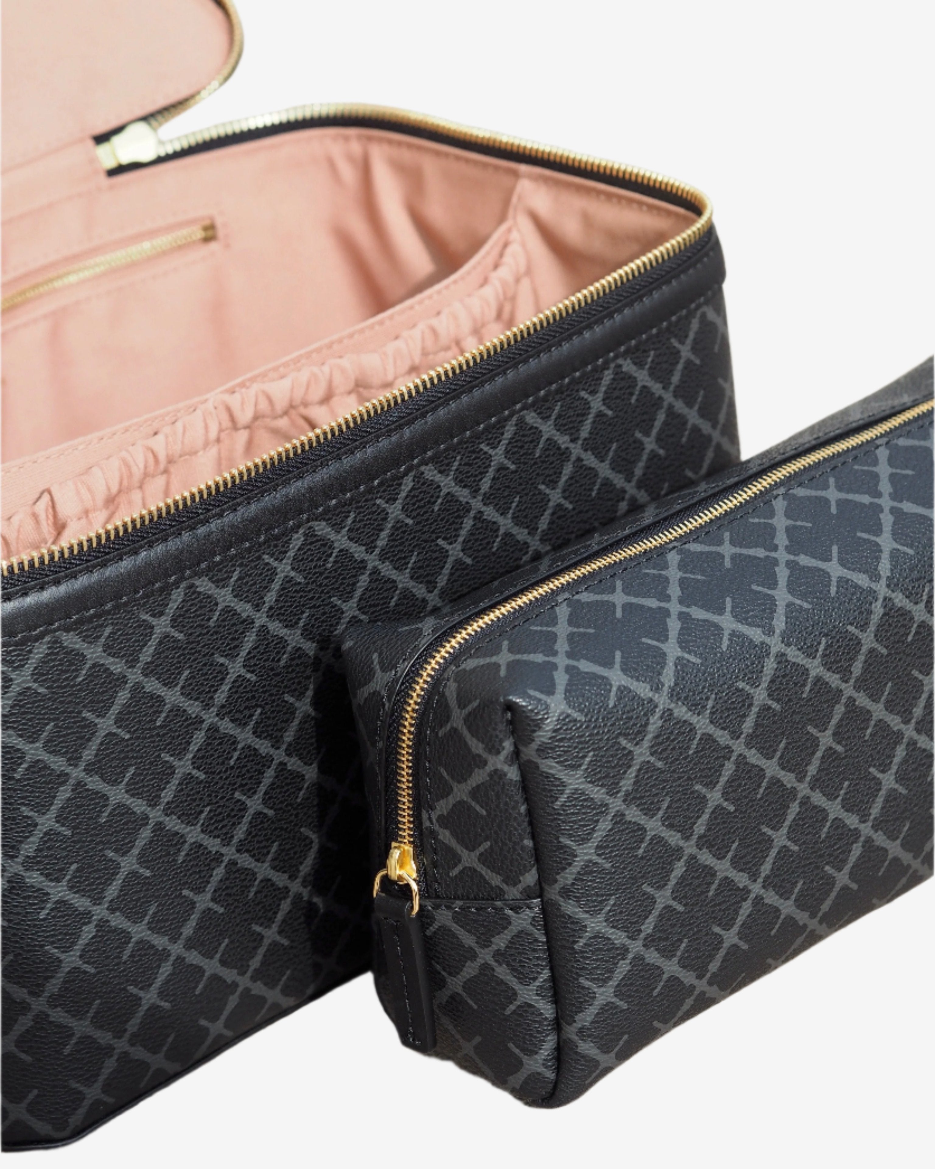 By Malene Birger Bae Beauty Box toalettmappe i mørkegrå, laget av polyvinylklorid med Signature Flower-print, med flere rom og en ekstra sminkepung.