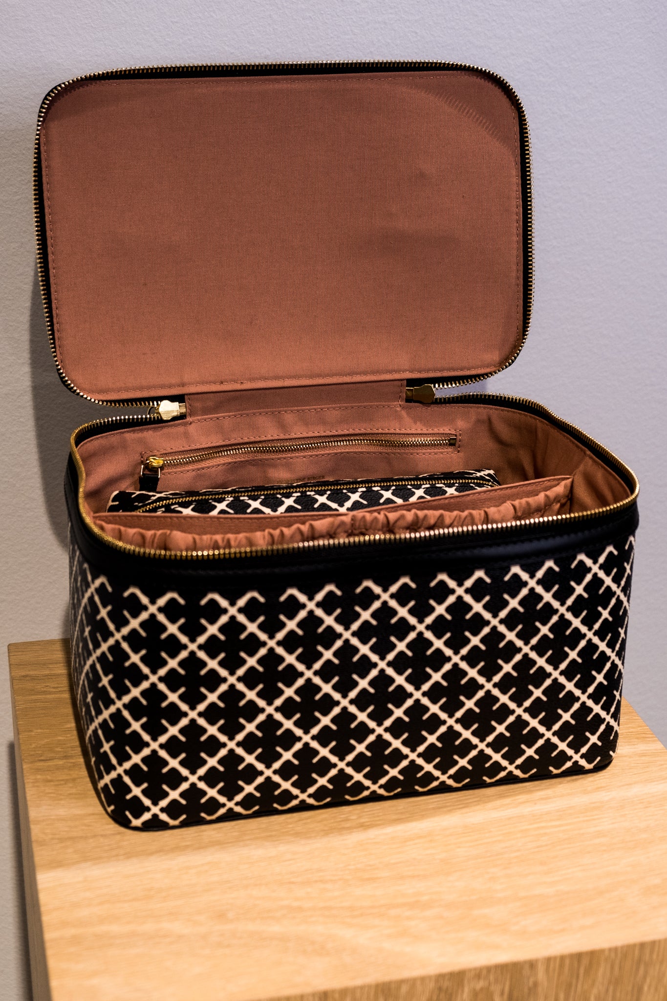 By Malene Birger Bae Beauty Box toalettmappe i sort, laget av polyvinylklorid med Signature Flower-print, med flere rom og en ekstra sminkepung.