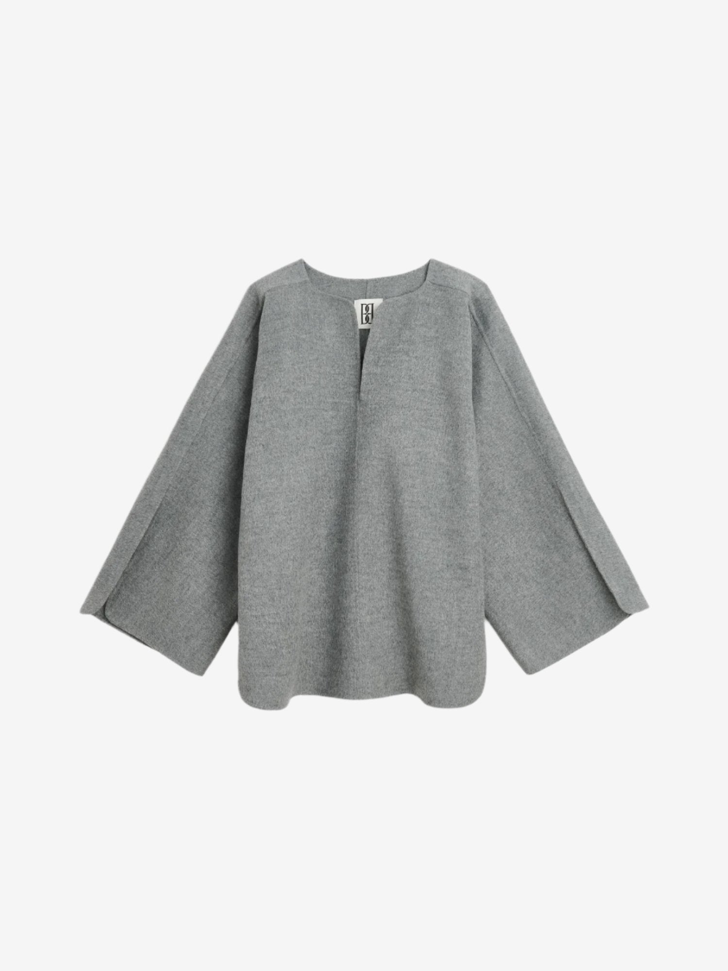 By Malene Birger Calias bluse i grå, laget av 100% ull, med v-utringning og splitt på ermene.